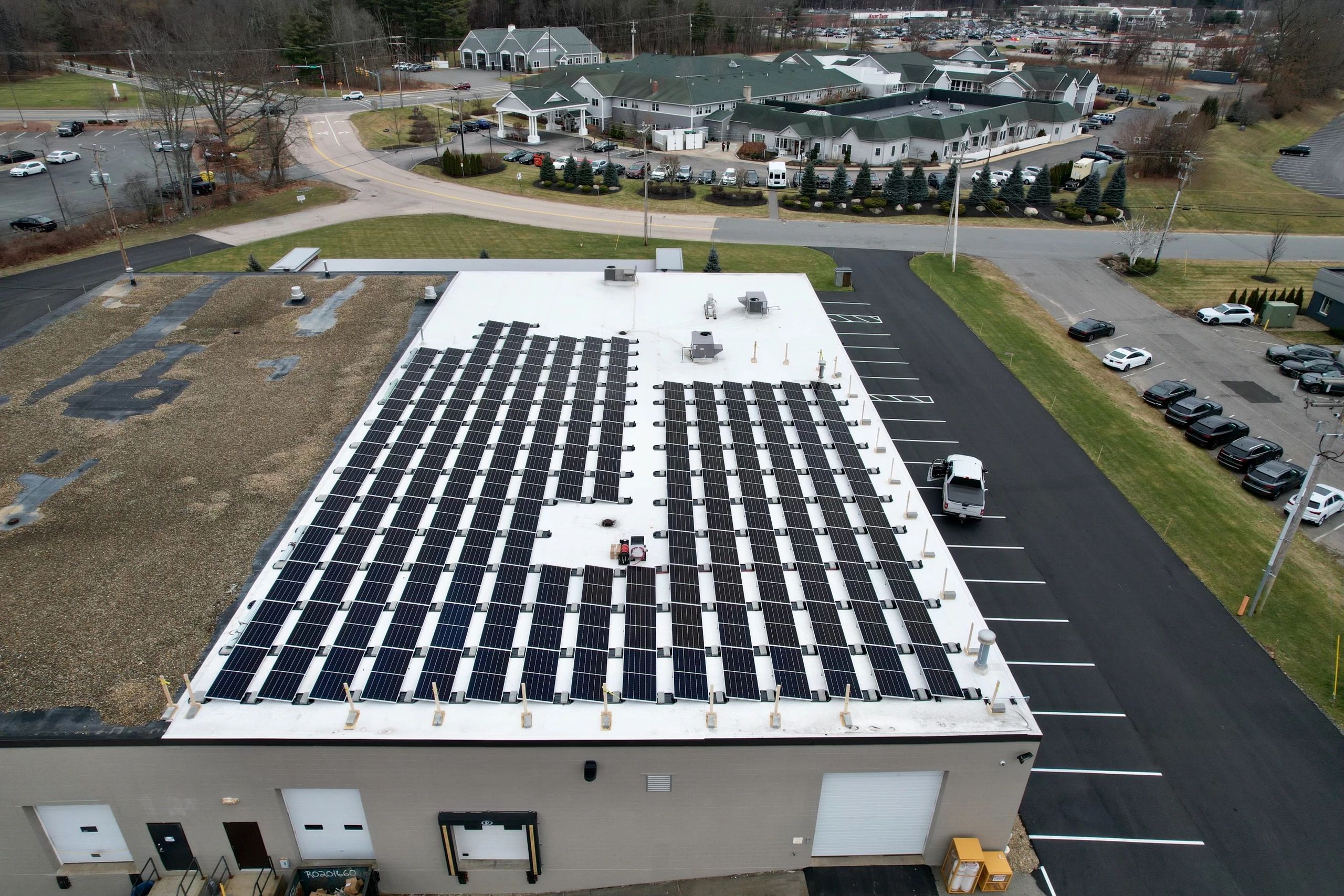 Aerial view of commercial rooftop solar installation in New England
